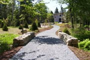 A road cleared through the woods at a custom landscape design. roads and paths
